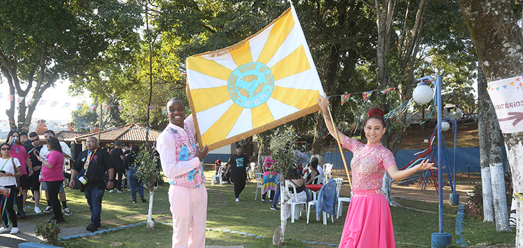 O casal de mestre-sala e porta-bandeira da Escola de Samba Rosas de Ouro se apresenta para o teleatendimento
